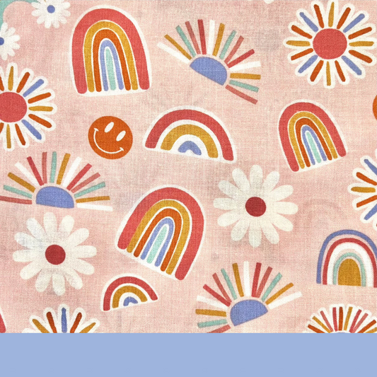 Close-up of Daisy Shift scrub cap fabric showing pink background with boho rainbows and sunshines in orange, periwinkle, and golden tones