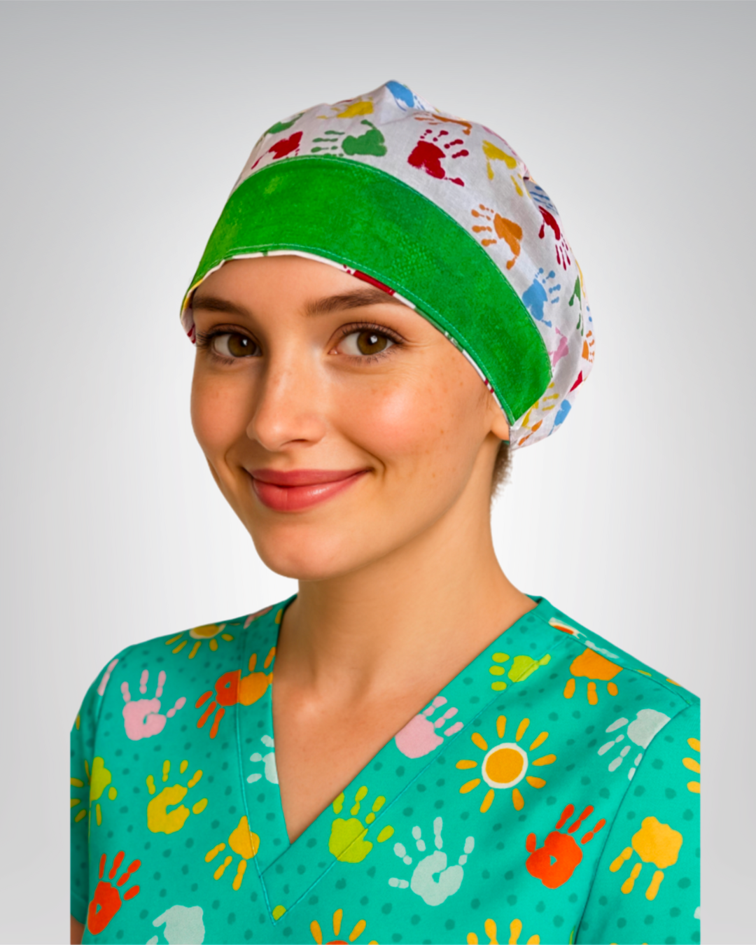 European style traditional scrub cap with white background, multicolor mini handprints, and green accents