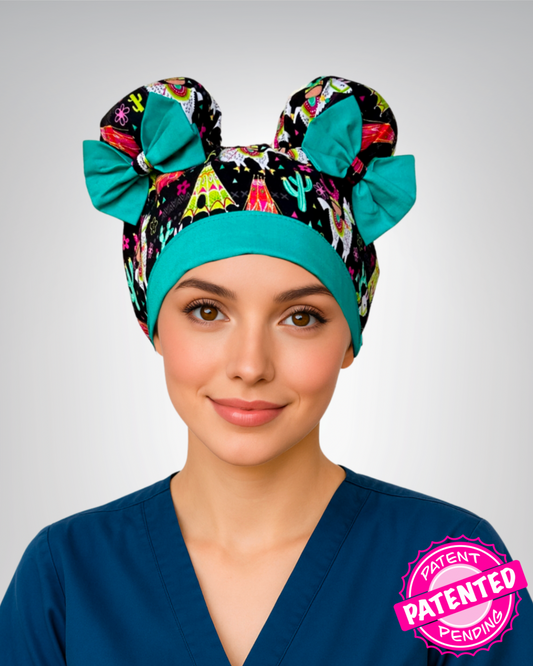 ScruBunz scrub cap with two space buns, black background, playful llamas, green tents, and colorful cacti