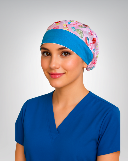Traditional European-style scrub cap with a pink background, colorful candy print, and sky blue accent trim